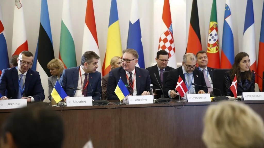 Представники ЄС на мирних переговорах по Україні за столом з прапорами країн Союзу