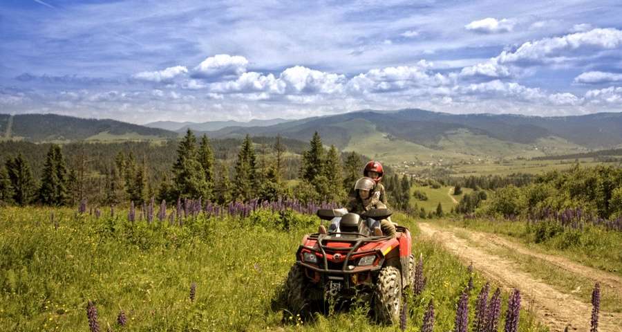 Турист на квадроциклі подорожує зеленими Карпатами влітку серед гір