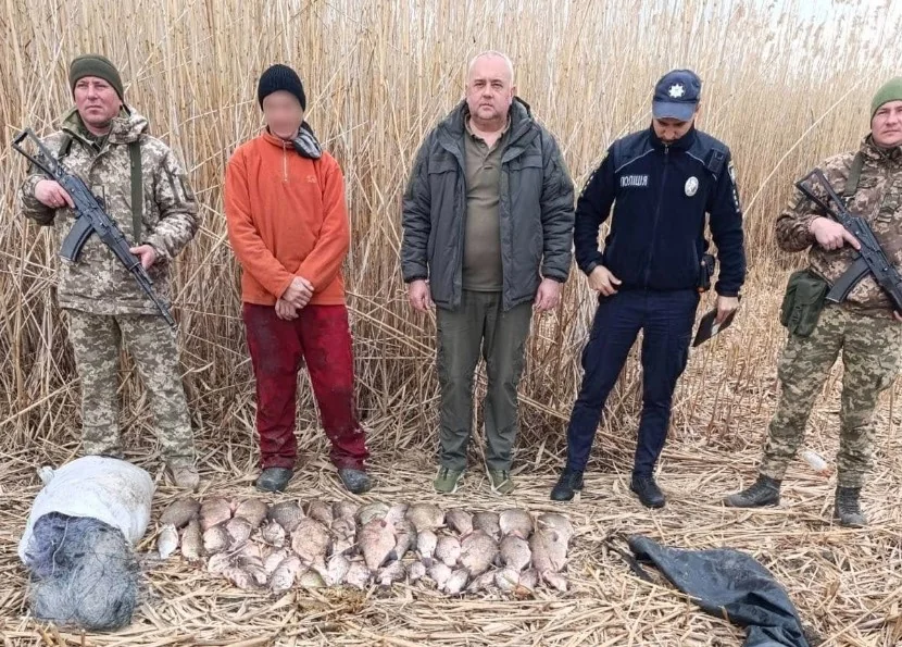 Затриманий рибалка-порушник з уловом та правоохоронцями біля водойми