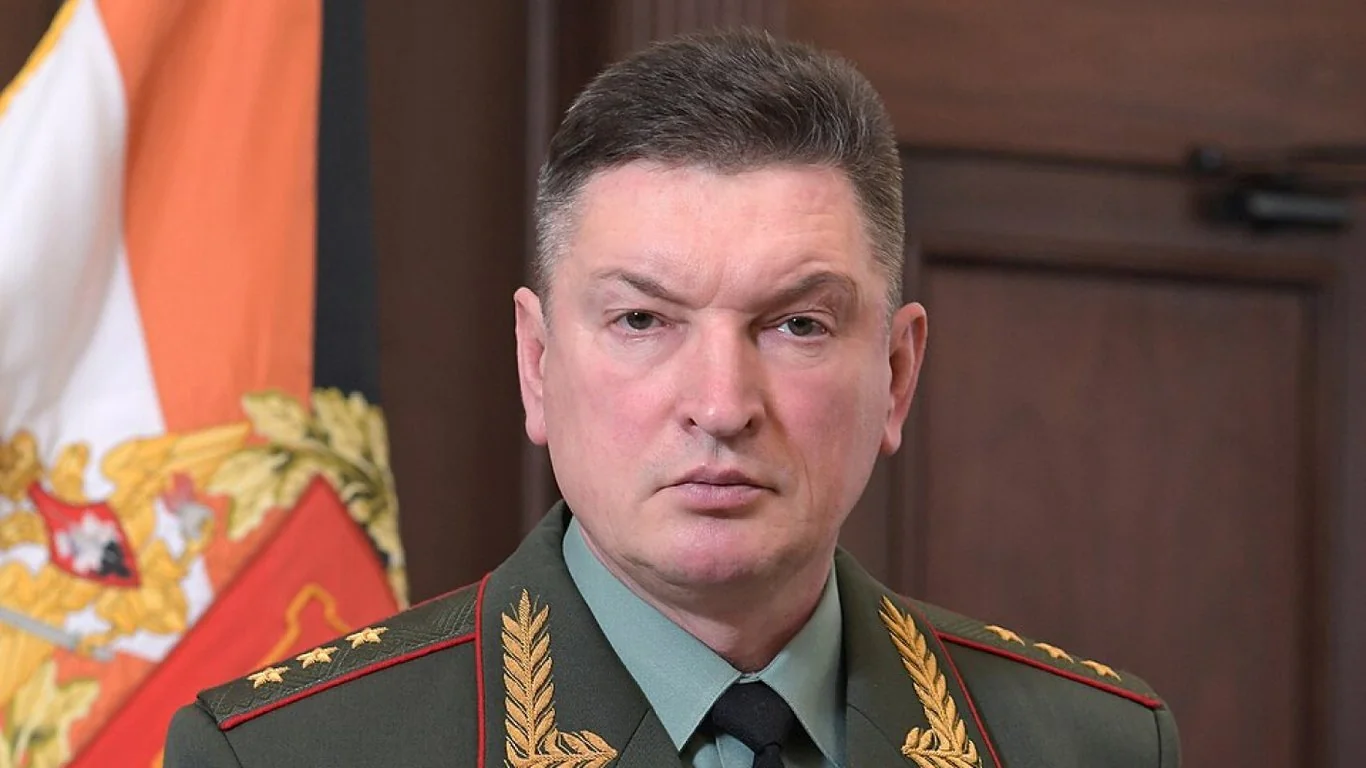 Генерал Олександр Лапін у парадній формі на тлі державного прапора