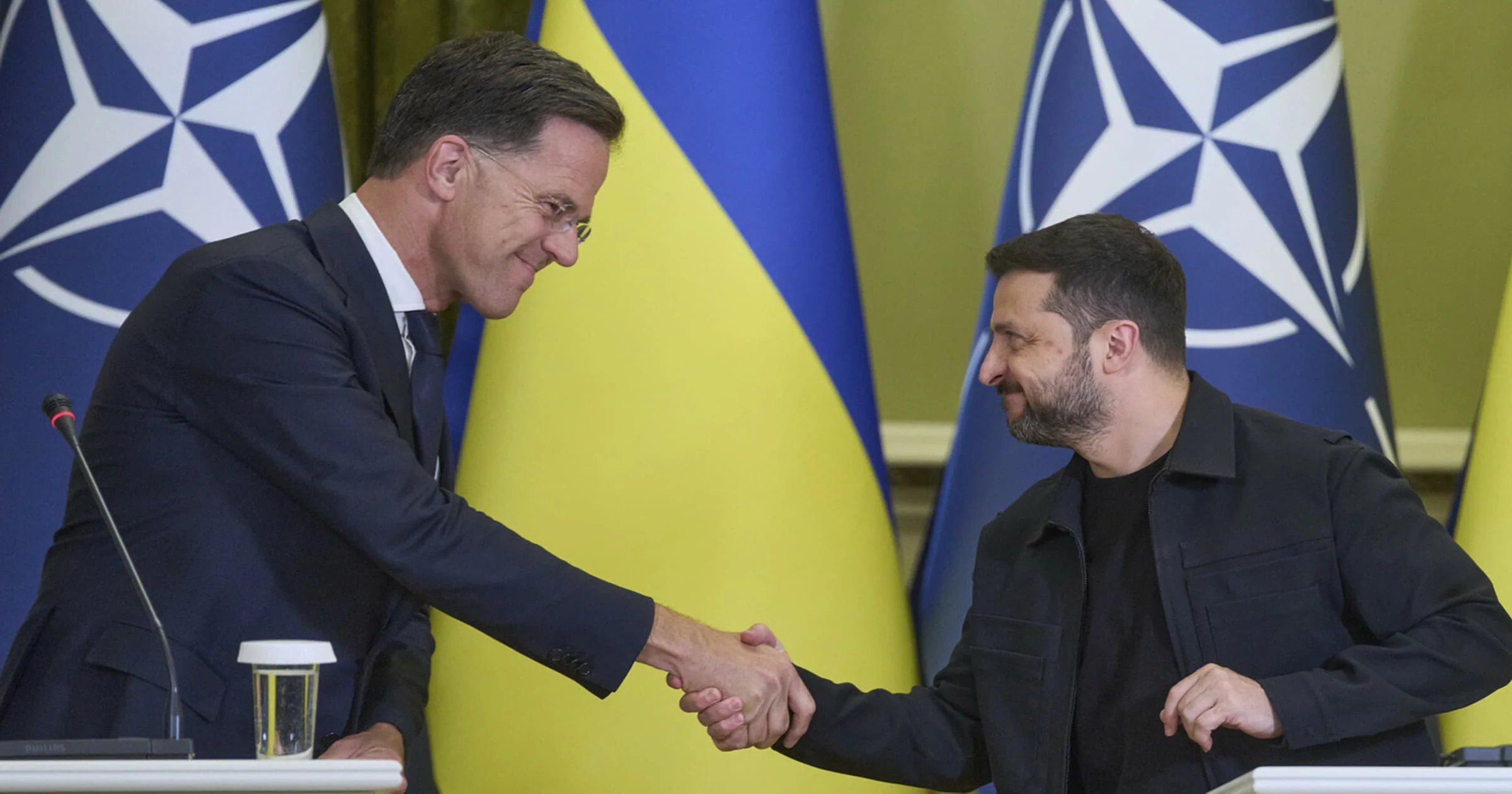 Зеленський і Рютте тиснуть руки на тлі прапорів України та НАТО