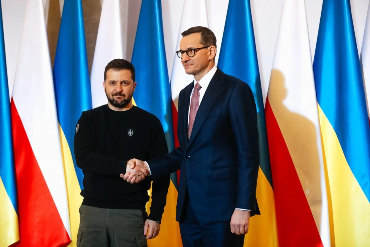 Зеленський і Туск тиснуть руки на тлі прапорів України та Польщі