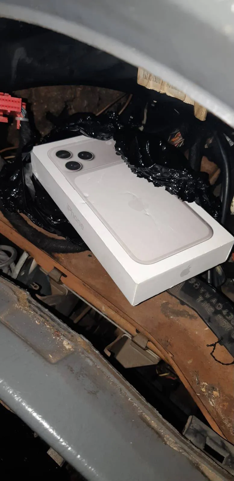 Коробка від iPhone у забрудненому моторному відсіку авто у Львові