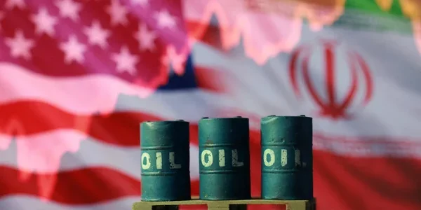 Нафтові бочки на тлі прапорів США та Ірану через конфлікт