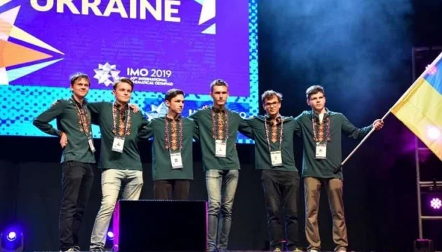 Українська команда переможців IMO 2019 з медалями та прапором на сцені