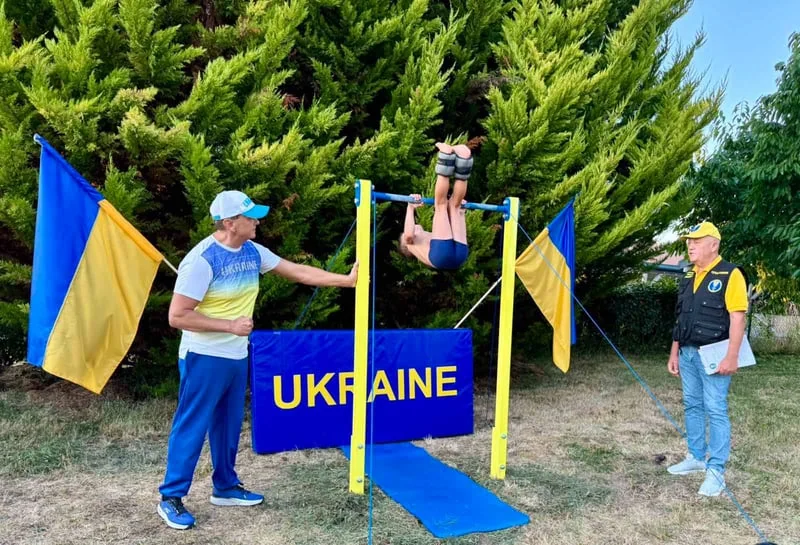 Семирічний Філіп Нагорний виконує підйом переворотом на перекладині з українськими прапорами