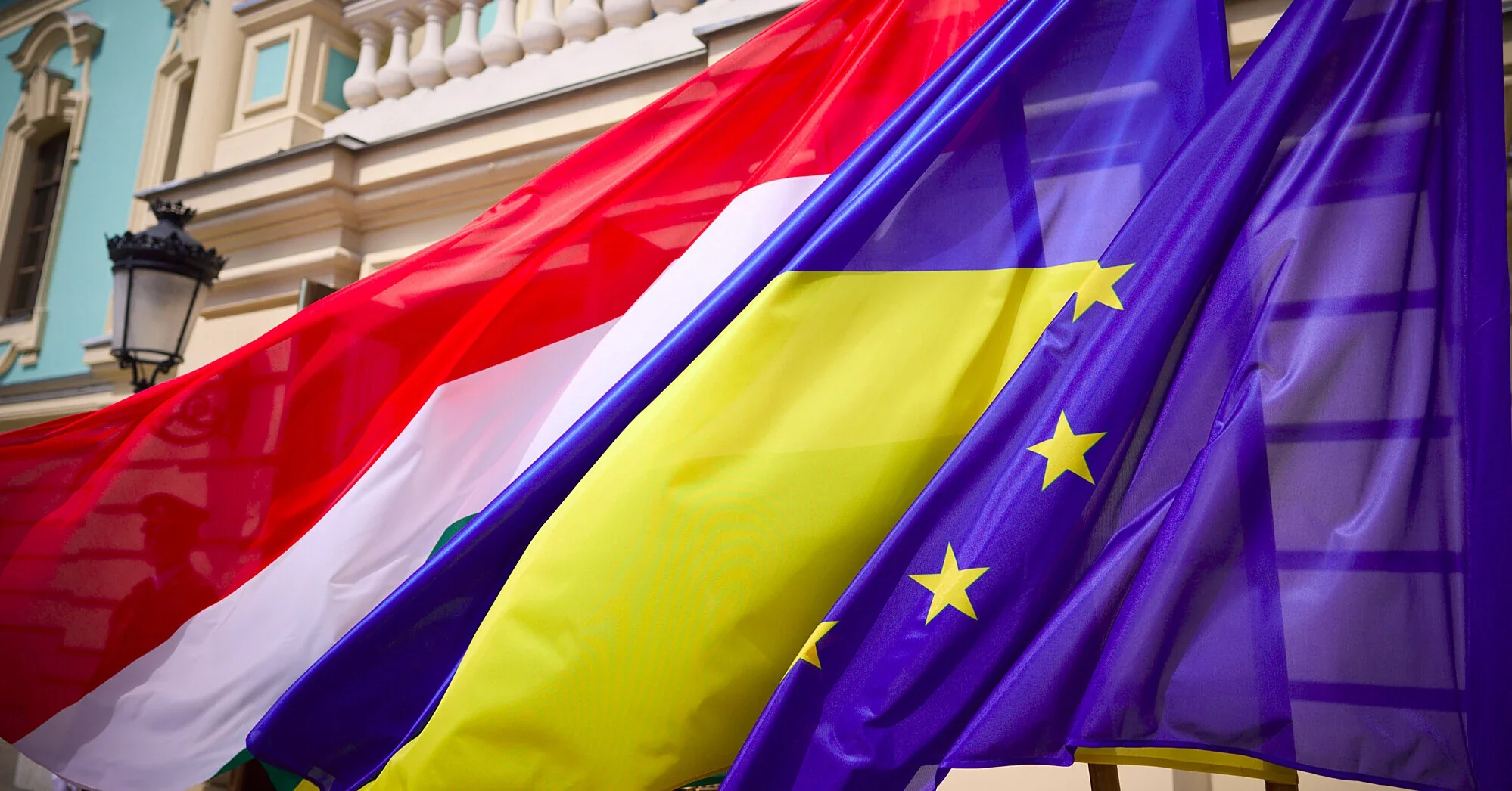 Прапори Угорщини, України та ЄС на тлі будівлі під час переговорів про вступ