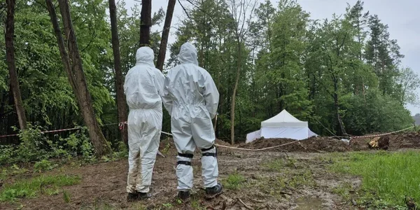 Експерти в захисних костюмах на місці пошуку останків у Ласкуві