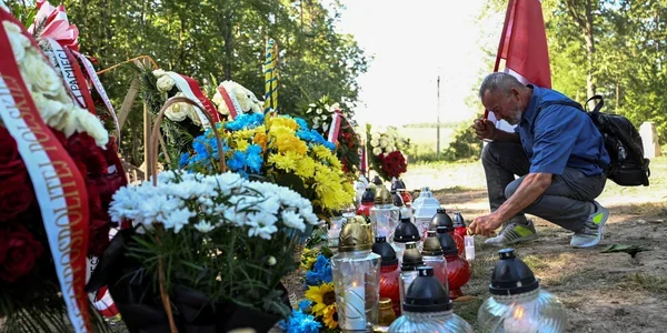 Чоловік вшановує пам’ять жертв Волинської трагедії 11 липня біля меморіалу