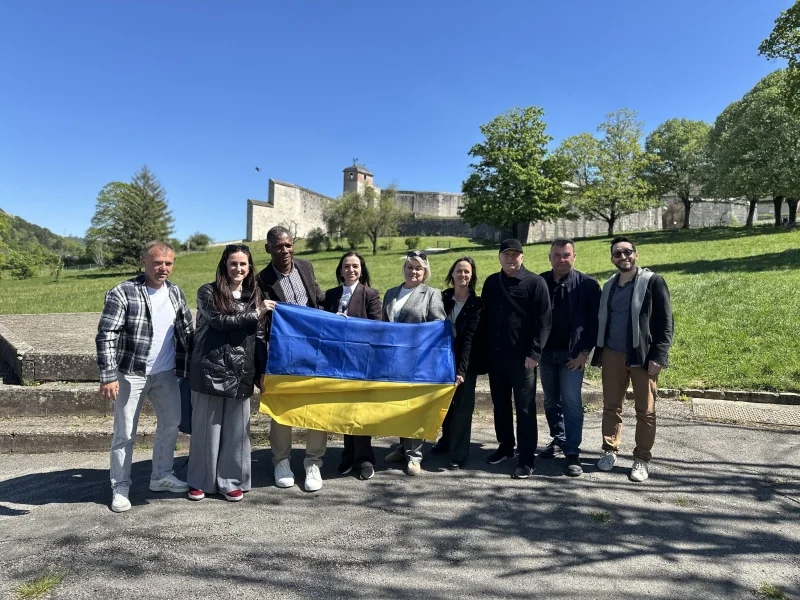 Українці тримають прапор біля замку у Франції після втечі від окупації